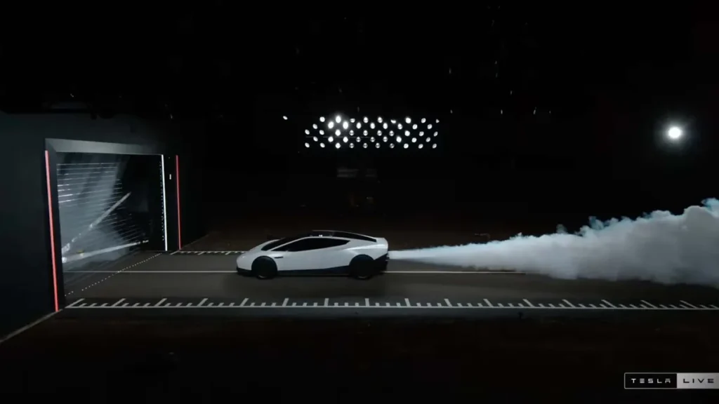 Elon Musk Unveils Flying Car, Demonstrates Tesla Roadster Driving Upside Down on Curved Ramp, Leaping into the Air, Performing a Flip and Landing on Its Wheels (Image 1)
